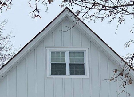 Light gray board and batten siding with white window trim on a North Jersey gable